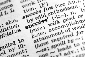 Success - Closeup macro of English dictionary page with word success