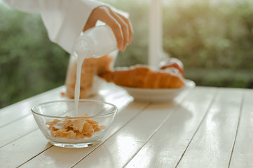 Young woman asia wake up refreshed in the morning and relaxing eat coffee, cornflakes, bread and apple for breakfast at house on holiday. Asian, asia, relax, breakfast, refresh, lifestyle concept.