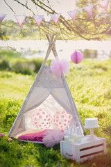 Decoration for children's photography with teepee and balloons at sunset.