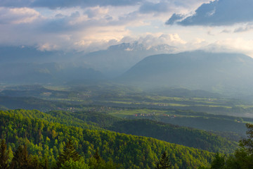 Slovenian breathtaking landscape at sunrise and Julian Alps in the background, in spring. Beautiful misty morning in the mountains in Slovenia.