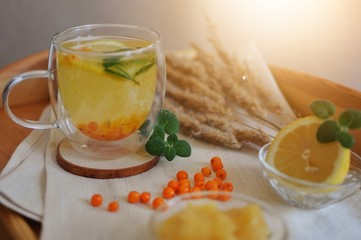 A glass of sea buckthorn tea with lemon and honey. Healthy drink against viruses