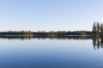in a lake of calm blue water the aroles of the coast are reflected, clear day and blue sky