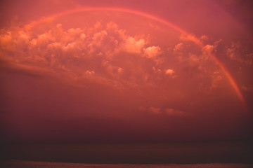 Fototapeta na wymiar Rainbow and evening sunset sky over the Florida sea coast