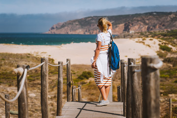 Adult female tourist enjoying costal view of Praia do Guincho Beach. Cascais, Portugal. This is...