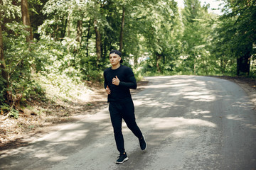 Handsome man in a park. Sportsman in a sportswear. Guy training