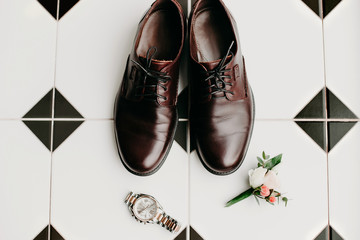 Men's shoes lie on the background of black and white tiles. Fees the groom. Wedding preparations. Composition in the morning of the groom