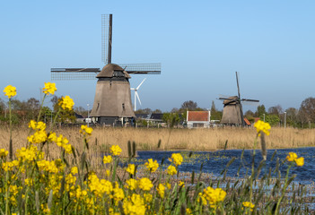 Krajobraz Holandii, wiatraki nad kanałem wodnym.