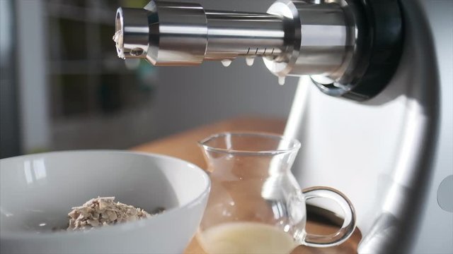 Homemade oil pressing. Press machine makes fresh homemade oil being on the kitchen on table. Camera orbits.