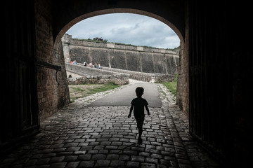 Little boy walking inside the gate of the Blaye castle.