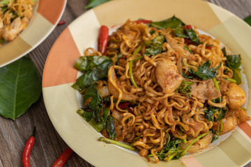 Spicy Fried Noodles with chicken on wooden table - Stock photo
