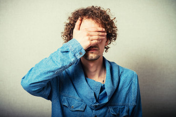 Portrait Of An Businessman Covering Eyes Isolated On Grey Background