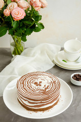 No baked zebra marble cheesecake with vanilla and chocolate layers on a white plate on a concrete background. Vertical orientation. Copy space.