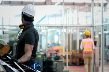 Industrial engineer worker wearing helmet, working with instrument at manufacturing plant factory, young beautiful woman working in industry