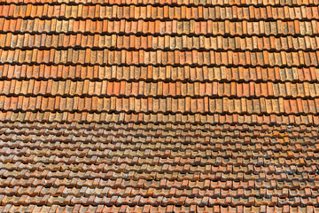 Texture of orange clay roof tiles at different angles. Red old dirty roof. Old roof tiles. Construction equipment build a house.