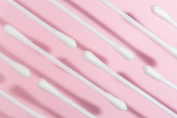 Hygienic stick for cleaning ears on pink background.