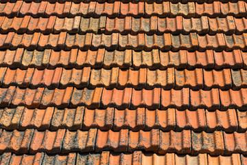 Texture of orange clay roof tiles. Red old dirty roof. Old roof tiles. Construction equipment build a house.