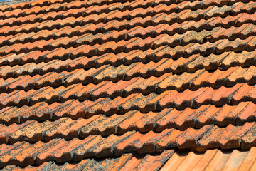 Close up of orange clay roof tiles at different angle. Red old dirty roof. Old roof tiles. Construction equipment build a house.