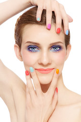 Young beautiful smiling girl with fancy bright makeup and colorful nail polish