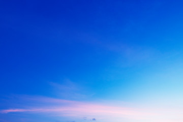 Colorful sunny blue sky with gradient pink, purple, orange color with white fluffy cloud on bright sunny horizon at twilight sunset or morning sunrise in tropical summer or spring sunlight & sun ray  