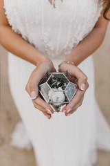 glass box with rings in the bride’s hands