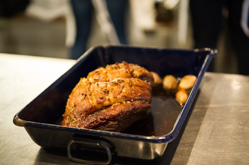 A big piece of roasted meat is ready to be served. Food for a big group of people