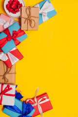 many multi-colored gifts for the holiday on a yellow background