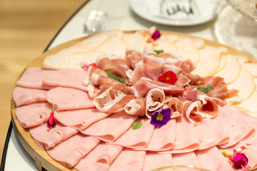 Sliced ham served on a wooden board on buffet table