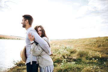 Close up portrait guy and girl hipster travel. Beautiful loving couple having fun, cuddling, smiling on sky background in field.