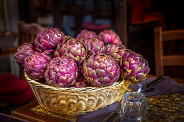 Piękne fioletowe karczochy w wiklinowym koszyku