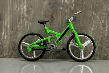 Fototapeta na wymiar Toy model - full-suspension mountain bike on a gray background