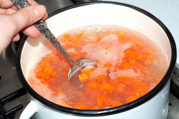 Diced carrot boiled in a white pan