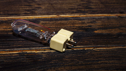 Close-up photo of halogen bulb with gx9.5 socket on a wooden background. Electric concept. Space...