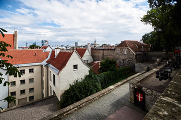 center of an old European city with stone walls and red tiled roofs on a sunny day. with steps and different tiers.