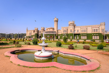 Beautiful exterior view of Bangalore Palace with a garden in front.