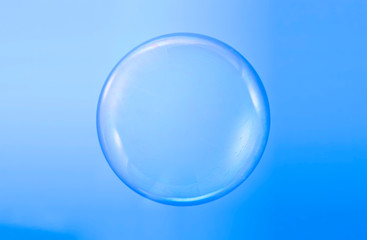Soap bubble ball water drop foam bubbles. Isolated on blue background