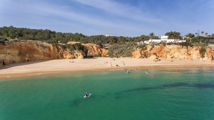 Young people in a practical surfing lesson, stand on the boards with oars. Portugal Algarve.