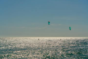 The athlete practices kate board surfing the sea on the waves. Summer in Portugal Algarve.