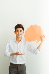 Portrait of an excited young  man holding empty speech bubble isolated over white background