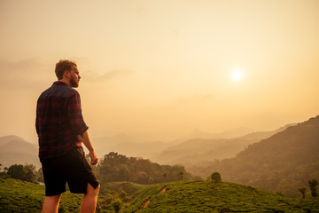 redhaired ginger male enjoying morning in India chai plantations Munnar