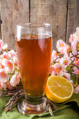 Indian Nannari sherbet drink, or refreshing summer lemonade cocktail, infused beverage with sarsaparilla roots, nannari syrup, herbs, citrus and spices, Wooden background copy space