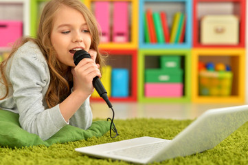 Portrait of adorable little girl singing karaoke
