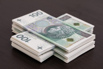 Banknotes evenly distributed on a dark brown desk ready for use.