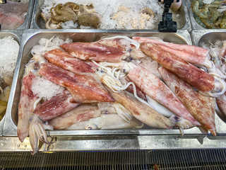 Pile of squids for sale at seafood stall in supermarket