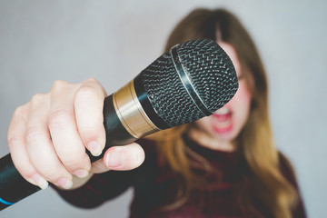 Young woman singing with a microphone