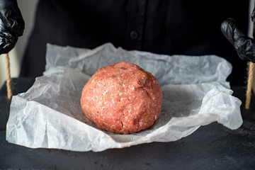 minced meat on paper, stone tray, black gloves