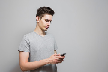 A guy in a gray T-shirt with emotions on his face.