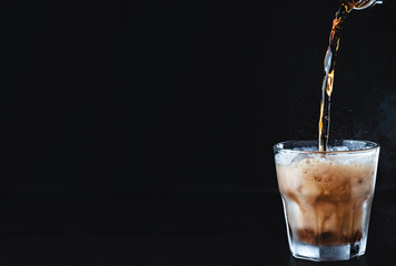 Cool non-alcoholic, carbonated cola drink is poured into a frozen, frost-covered glass with ice....