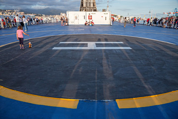 Some tourists stroll on the ferry deck awaiting departure from the port of Genoa, Italy.