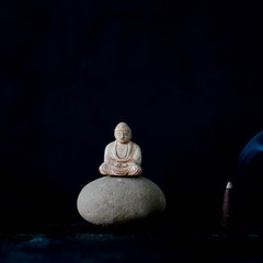 .Buddha on a stone near aroma sticks