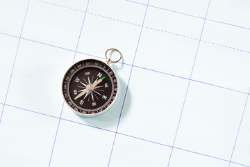 A compass on a map over the sea.